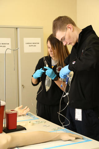 Paramedic Students Preparing IV in Classroom Exercise