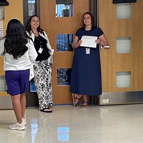 8th Grade teachers greet a student