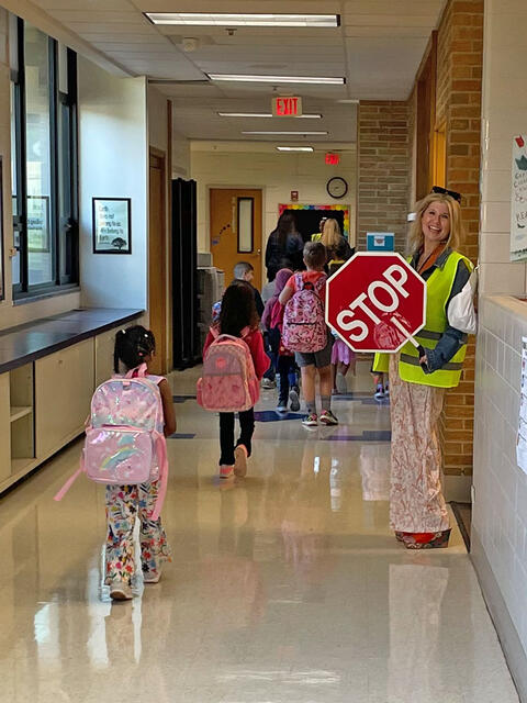 Mrs. Szalewski greets students on their way up the hall