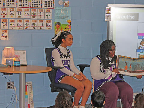 photo of big kid students reading to little kid students