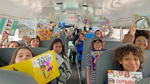 photo of students on the bus with books