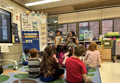 students sitting on rug with teacher